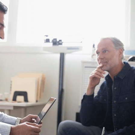 Doctor using iPad in front of patients Doctor using iPad in front of patients