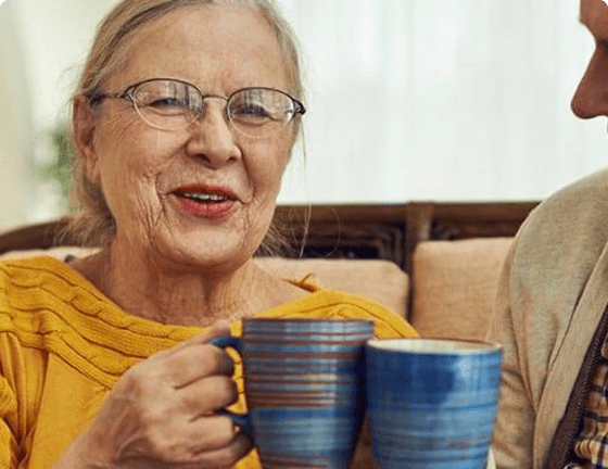 Elderly couple sitting together drinking hot drink Elderly couple sitting together drinking hot drink