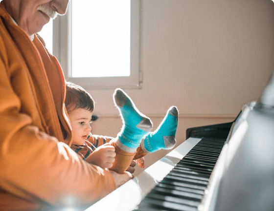 Grandfather and toddler sitting at a piano Grandfather and toddler sitting at a piano
