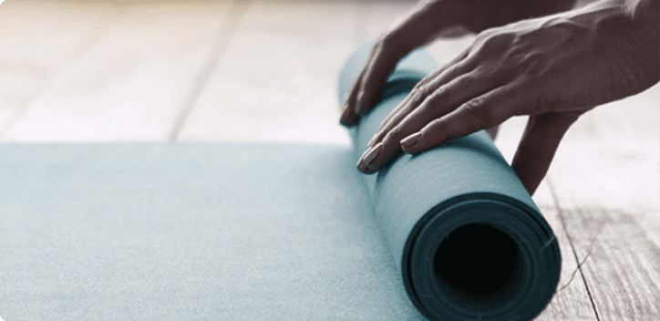 Hands rolling a yoga mat Hands rolling a yoga mat